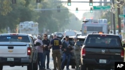 Law enforcement officials investigate the scene of a mass shooting at a Dollar General store, Aug. 26, 2023, in Jacksonville, Florida.