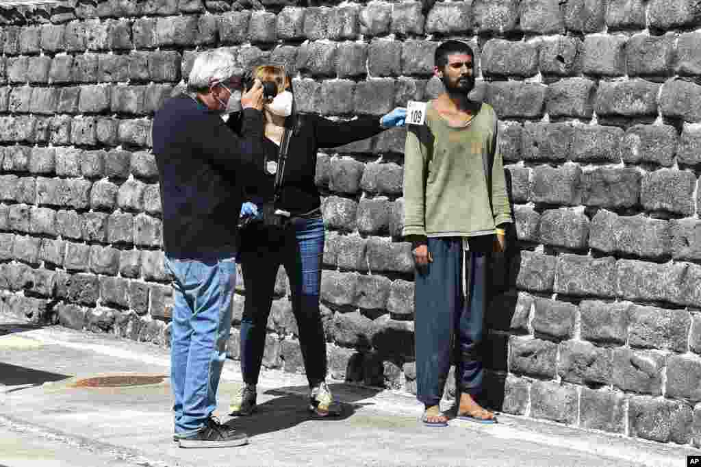 Migrants are identified by Italian officials as they get off a ship in the Sicilian port of Catania.