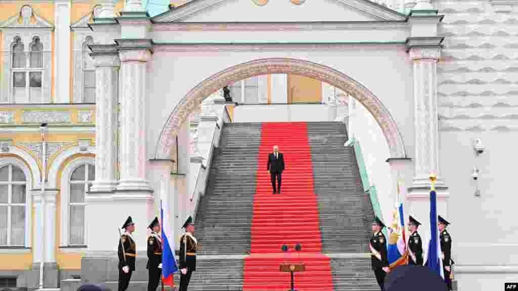 Russian President Vladimir Putin walks down the steps to address troops gathered on the Sobornaya Square from the porch of the the Palace of the Facets on the Kremlin grounds in Moscow.