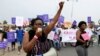 FILE - Hundreds of Angolans hold placards and shout slogans as they march to protest against a draft law that would criminalize all abortion on March 18, 2017 in Luanda, Angola. 