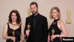 Ukrainian filmmaker Mstyslav Chernov, center, Raney Aronson-Rath and Michelle Mizner, right, pose with the Oscar for Best Documentary Feature Film for "20 Days in Mariupol," at the 96th Academy Awards in Hollywood, Los Angeles, California, March 10, 2024. 