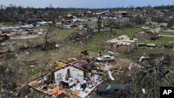 FILE - Debris is strewn about tornado damaged homes, Sunday, March 26, 2023, in Rolling Fork, Miss.