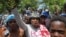 Residents of the neighborhood Carrefour Feuilles gather outside a military base demanding help after they had to flee their homes when gangs took over, in Port-au-Prince, Haiti Aug. 16, 2023. 