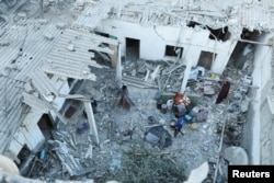 Palestinians inspect the site of an Israeli strike on a house, amid the Israel-Hamas conflict, in Deir Al-Balah in the central Gaza Strip, Aug. 4, 2024.