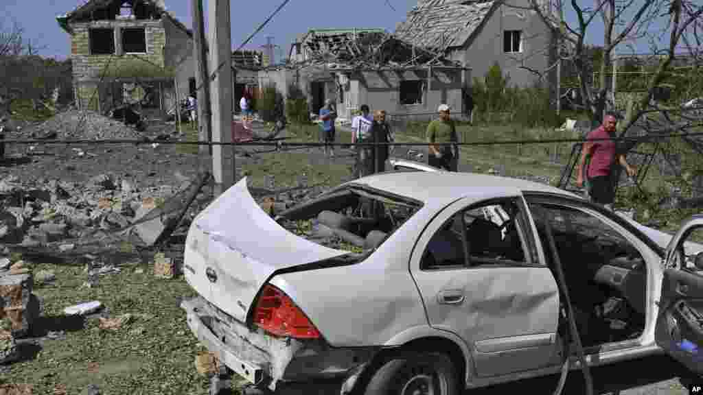 Varias personas caminan frente a sus casas dañadas tras el ataque con misiles rusos en la aldea de Usatove, cerca de Odesa, Ucrania, el lunes 26 de agosto de 2024. (Foto AP/Michael Shtekel) &nbsp;