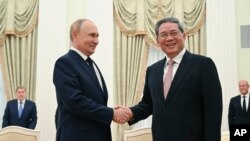 Russian President Vladimir Putin, left, and Chinese Premier Li Qiang shake hands during their meeting at the Kremlin in Moscow, Russi, Aug. 21, 2024. 