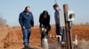 Texas Tribune reporter Jayme Lozano checks out an e-line water level meter attached to a water well near the High Plains Underground Water Conservation office in Lubbock, Texas, in December of 2023. (Mark Rogers/Texas Tribune)