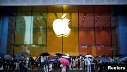 Orang-orang berdiri di luar Apple Store saat iPhone 15 baru Apple secara resmi mulai dijual di seluruh China, di Shanghai, China, 22 September 2023. (Foto: REUTERS/Aly Song)
