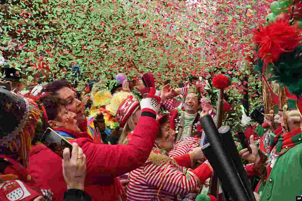 Orang-orang yang bersuka ria merayakan festival tradisional Alter Markt, saat dimulainya karnaval jalanan tahunan di kota Cologne, Jerman.