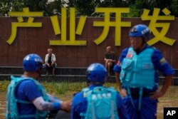 Warga dan tim penyelamat beristirahat di luar pabrik saat warga dievakuasi dari banjir di Zhuozhou di provinsi Hebei, China utara, selatan Beijing, Rabu, 2 Agustus 2023. (AP/Andy Wong)