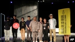 Lit Ming-wai, second from right, and performers pose on the stage of drama "May 35th" in Taipei, Taiwan, Thursday, June 1, 2023.