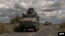 Ukrainian armored military vehicles drive from the direction of the border with Russia, in Ukraine's Sumy region, Aug. 13, 2024.