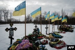 Bendera Ukraina melambai di atas kuburan prajurit Ukraina yang gugur di sebuah pemakaman, di tengah invasi Rusia ke Ukraina. (Foto: AFP)