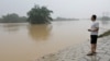 A resident looks on as he stands near a flooded river following heavy rainfall in Qingyuan, Guangdong province, China, April 22, 2024. 