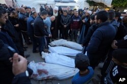 Warga Palestina berduka atas kematian kerabat mereka dalam pemboman Israel di Jalur Gaza di depan kamar mayat Rumah Sakit Al Aqsa di Deir al Balah, Kamis, 29 Februari 2024. (AP Photo/Adel Hana)