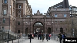 FILE - Pedestrians walk through the buildings of Sweden's Parliament in Stockholm, Sweden, Feb. 25, 2024. 