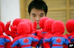 FILE - A worker checks Spider-Man dolls assembled at the production line of Dongguan Da Lang Wealthwise Plastic Factory in Dongguan, China, Sept. 4, 2007. U.S. toy makers are finding the cost of doing business with Chinese producers is rising.