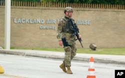 FILE - A military policeman stands guard at JBSA-Lackland Air Force Base, in San Antonio, June 9, 2021.