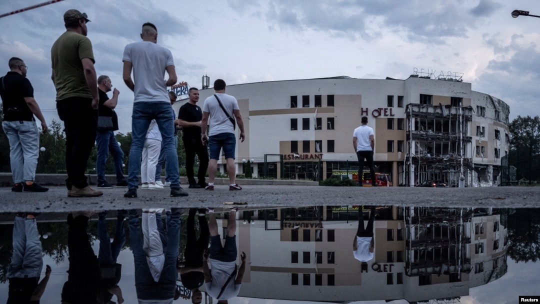 People stand near the site of a Russian missile strike, amid Russia's attack on Ukraine, in Zaporizhzhia, Aug. 10, 2023.