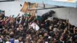 Palestinians gather to receive aid outside an UNRWA warehouse as Gaza residents face crisis levels of hunger, amid the ongoing conflict between Israel and Hamas, in Gaza City, March 18, 2024.