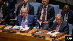 U.N. Secretary General Antonio Guterres, right, listens during a U.N. Security Council meeting on the protection of civilians in armed conflict, at U.N. headquarters in New York, May 23, 2023. At left is Russia's U.N. representative Vassily Nebenzia.