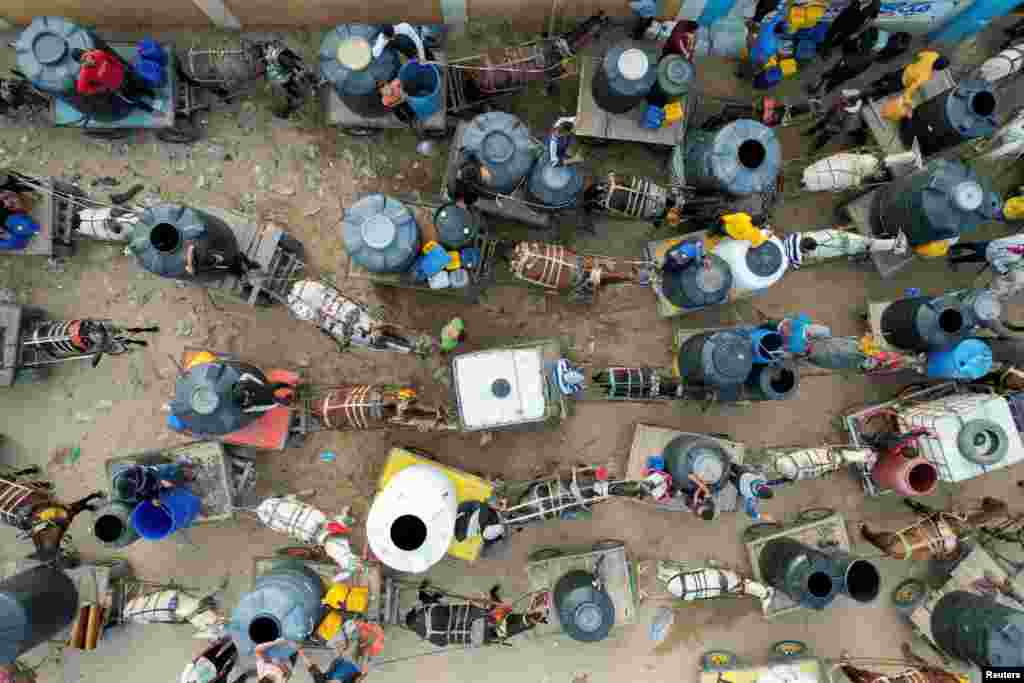 Palestinians with animal-drawn carts collect water from a water desalination plant, amid water shortages, as the conflict between Israel and the Palestinian Islamist group Hamas continues, in central Gaza Strip.