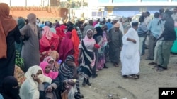 (FILE) People displaced by the ongoing conflict in Sudan between the army and paramilitaries wait to receive aid from a charity in Sudan.