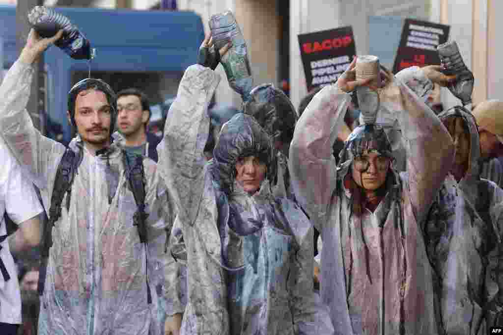 فعالان محیط زیست و اقلیم در تظاهراتی در شهر پاریس، پایتخت فرانسه، در یک حرکت نمادین بر بدن شان محصولات نفتی ریختند
