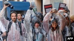 Climate protesters pour oil over themselves as scuffles between police and protesters broke out with the use of tear gas during a demonstration on the outskirts of the Paris venue for TotalEnergies Annual General Meeting in Paris.