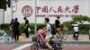 People past near the logo for Renmin University outside the main campus in Beijing, July 22, 2024. A PhD student at Renmin University accused her supervisor of molesting her and taking revenge after being rejected. 