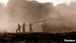 Israeli soldiers clean a tank gun barrel after returning from the Gaza Strip, amid the ongoing conflict between Israel and Hamas, near the Israel-Gaza border, in Israel, June 5, 2024.