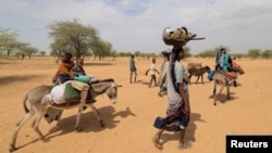 Sudanese families fleeing the conflict in Sudan's Darfur region make their way through the desert after they crossed the border between Sudan and Chad to seek refuge in Goungour, Chad, May 12, 2023.