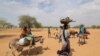 Sudanese families fleeing the conflict in Sudan's Darfur region make their way through the desert after they crossed the border between Sudan and Chad to seek refuge in Goungour, Chad, May 12, 2023.