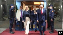 在台湾外交部发布的照片中，2023年5月16日英国前首相利兹·特拉斯抵达台湾桃园机场时，与台湾外交部长吴钊燮一起行走