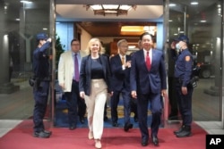 在台湾外交部发布的照片中，英国前首相利兹·特拉斯2023年5月16日抵达台湾桃园机场时，与台湾外交部长吴钊燮一起行走。（美联社照片）
