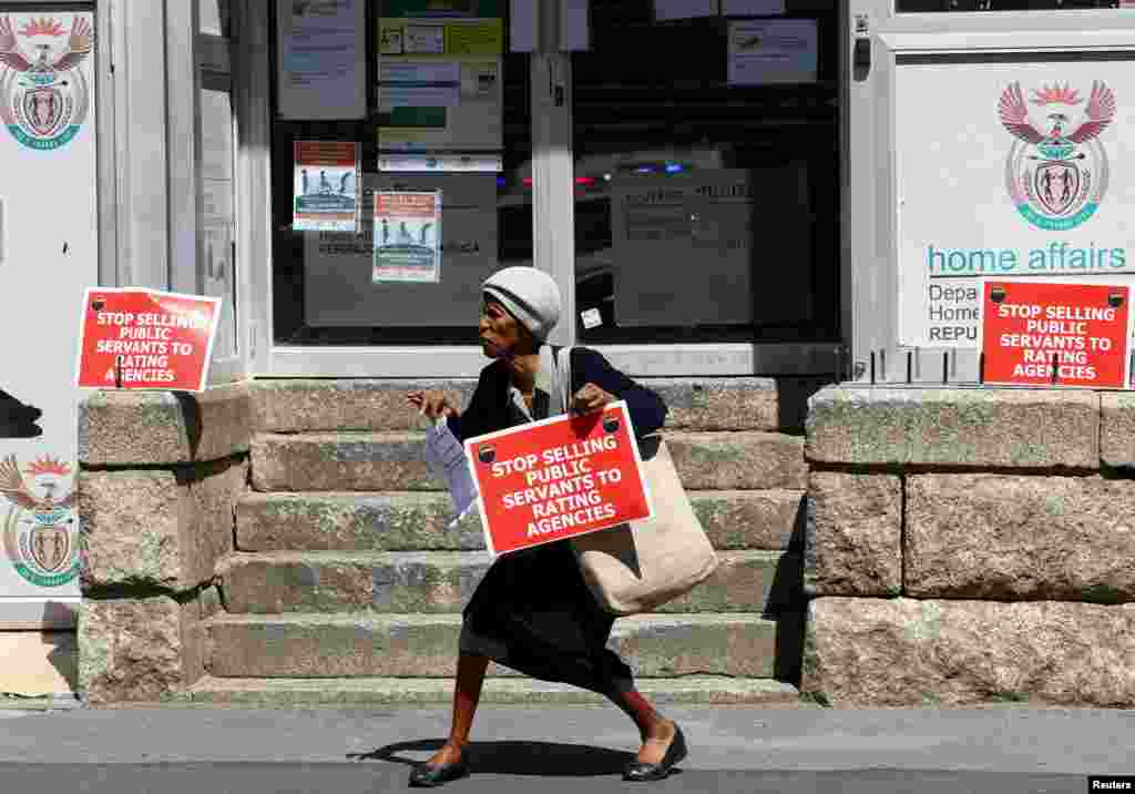 Член на синдикатот на јужноафриканскиот јавен сектор држи плакат пред канцеларијата за внатрешни работи за време на протестот поради спорови за платите и други работни прашања во Кејп Таун.