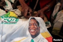 FILE: Juda Zunze, a tailor, works on a bag with an image of Zimbabwe's President Emmerson Mnangagwa, in his workshop in Warren Park, Harare, Zimbabwe July 18, 2023. REUTERS/Philimon Bulawayo