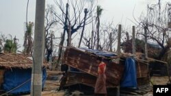 FILE - A woman walks past her temporary house following fighting between Myanmar's military and the Arakan Army ethnic minority armed group in a village in Minbya Township in western Rakhine state, May 21, 2024.