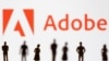 Figurines are seen in front of displayed Adobe logo in this illustration taken June 13, 2022. (REUTERS/Dado Ruvic/Illustration)