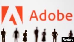 Figurines are seen in front of displayed Adobe logo in this illustration taken June 13, 2022. (REUTERS/Dado Ruvic/Illustration)