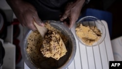 FILE - A private chef prepares cooked beans mashed in boiled sweet potatoes, in Nairobi, Kenya, Dec. 16, 2021.