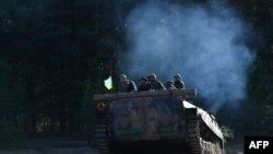 Servicemen of Ukrainian first presidential brigade "Bureviy" ride an armored personnel carrier (APC) in the Chernihiv region on October 13, 2023, before deployment on the front line.