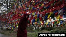 FILE - A Tibetan monk prays as he circumambulates clockwise around Tsuglakhang, also known as Dalai Lama's Temple complex, as it rains, in the northern hill town of Dharamsala, India, March 12, 2024.