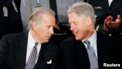 FILE - U.S. President Bill Clinton talks with Senator Joseph Biden at a meeting with law enforcement officers at the Alexandria, Virginia, Jan. 14, 1999.