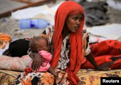 Seorang ibu menyusui anaknya yang kekurangan gizi parah di kamp pengungsi di kota Afdera, wilayah Afar, Ethiopia, 23 Februari 2022. (REUTERS/Tiksa Negeri)