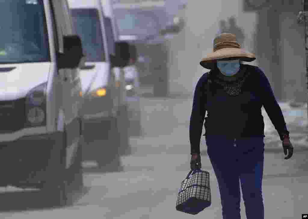 Una mujer camina por las calles cubiertas de ceniza del volcán Popocatépetl en Santiago Xalitzintla, México, el lunes 22 de mayo de 2023.&nbsp;No se han ordenado evacuaciones, pero las autoridades se preparan para ese escenario.