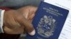 Migrante venezolano tiene su pasaporte en una cola para obtener un permiso de residencia temporal fuera de la oficina de inmigración en Lima, Perú, el 20 de agosto de 2018.
