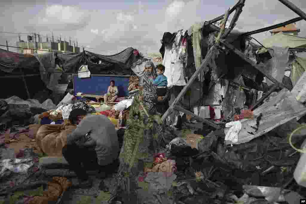 Keluarga pengungsi Palestina memeriksa tenda-tenda mereka yang hancur akibat pemboman Israel, di samping fasilitas UNRWA di sebelah barat kota Rafah, Jalur Gaza, 28 Mei 2024. (AP)&nbsp;