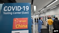 Petugas kesehatan memandu pelancong yang tiba dari China di pusat pengujian Covid-19 di Bandara Internasional Incheon, sebelah barat Seoul, 3 Januari 2023. (Jung Yeon-je / AFP)