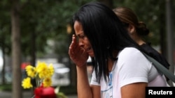 FILE - A woman reacts during a ceremony marking the 21st anniversary of the September 11, 2001 attacks on the World Trade Center at the 9/11 Memorial and Museum in the Manhattan borough of New York City, Sept. 11, 2022.